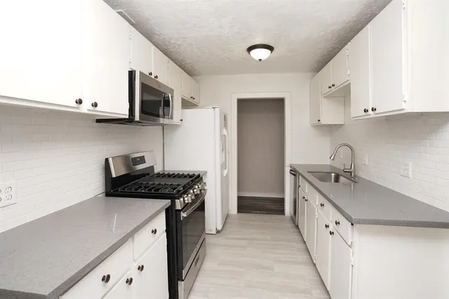 a kitchen with stainless steel appliances granite countertop a sink stove and cabinets