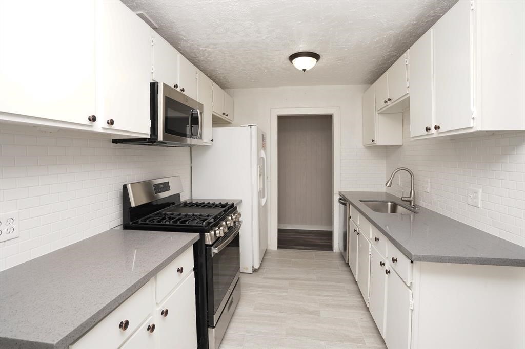 805 Horncastle Street Channelview, TX 77530 - Photo 6 of 12 a kitchen with stainless steel appliances granite countertop a sink stove and cabinets