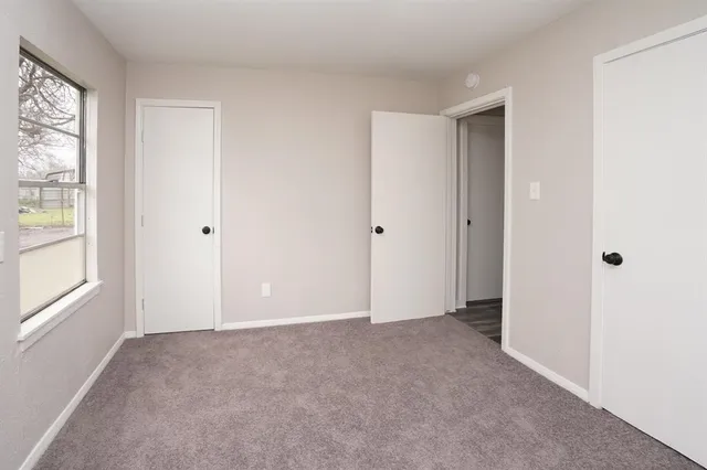a view of an empty room with windows and closet
