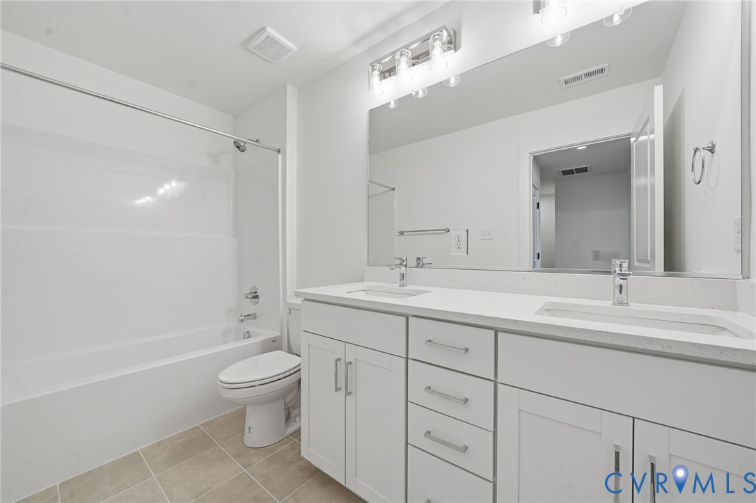 12049 Flowering Lavender Loop Henrico, VA 23233 - Photo 19 of 29 a bathroom with a double vanity sink toilet mirror and bathtub