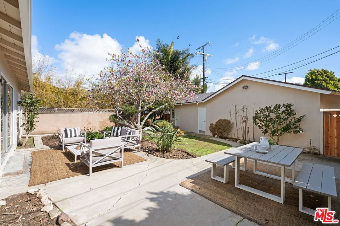 1012 Rose Avenue Venice, CA 90291 - Photo 22 of 27 a view of a patio with couches table and chairs under an umbrella with a fire pit