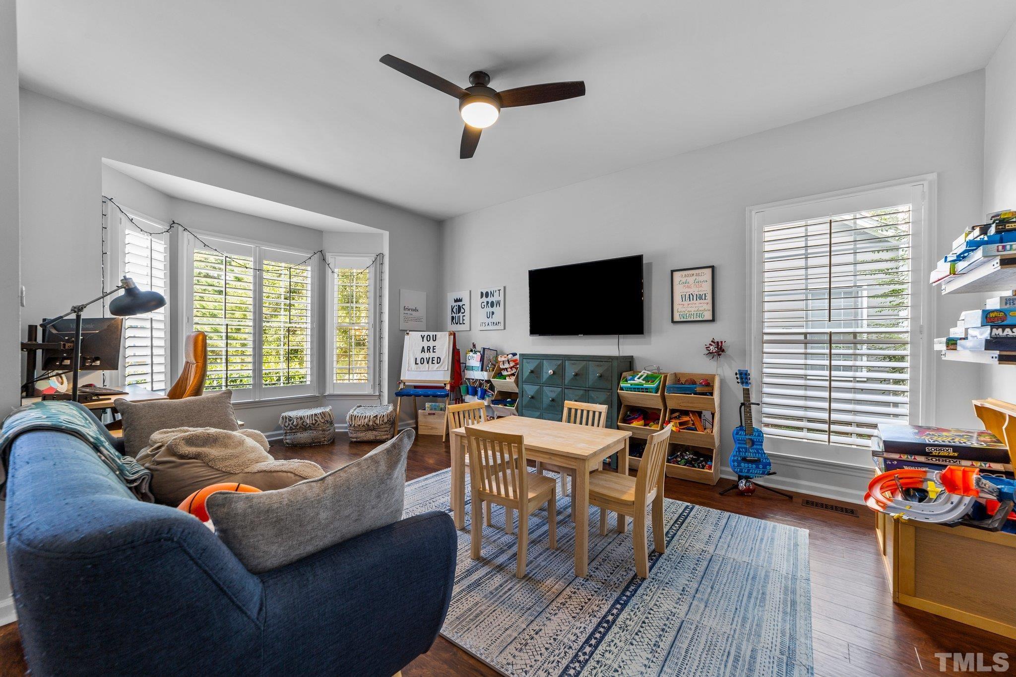 5216 Halcott Court Raleigh, NC 27613 - Photo 8 of 22 a living room with furniture a flat screen tv and a large window