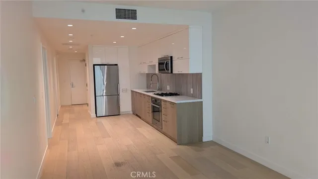 a kitchen with stainless steel appliances a refrigerator and a stove top oven