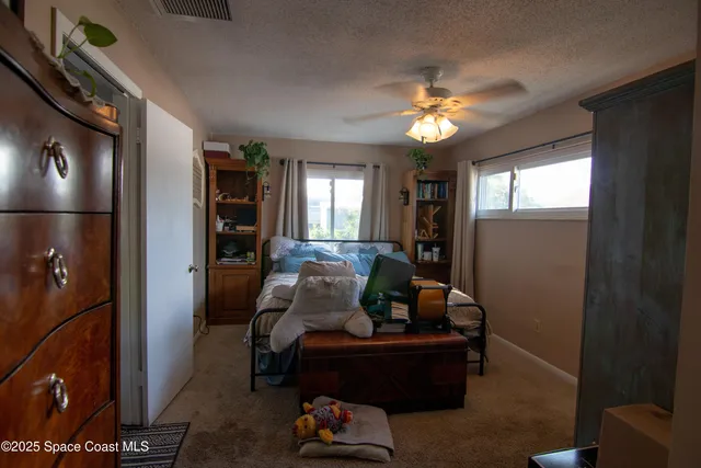 a bedroom with a large bed a flat tv screen and a walk in closet