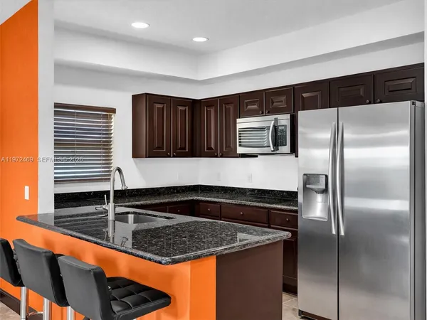 a kitchen with granite countertop stainless steel appliances a sink and cabinets