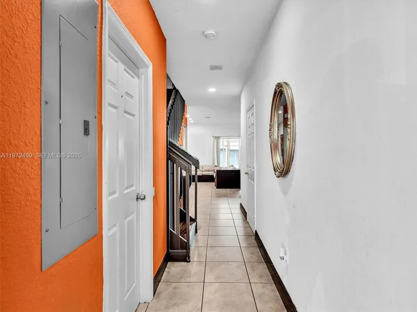 a living room with stainless steel appliances furniture a refrigerator and a stove top oven