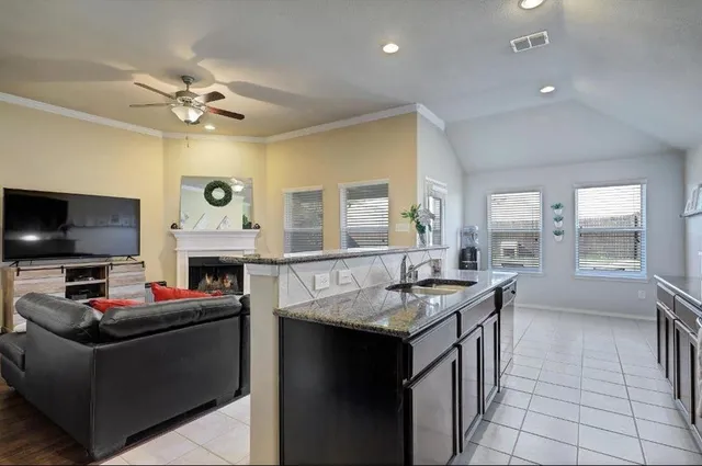 a kitchen with granite countertop a sink counter top space appliances and a window