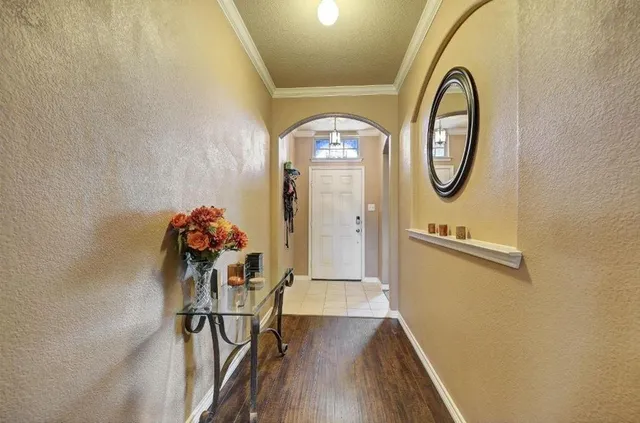 a view of a hallway with wooden floor and glass windows