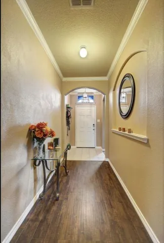 a view of a hallway with furniture and wooden floor