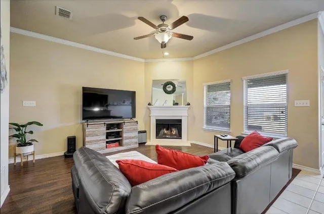 a living room with furniture a fireplace and a flat screen tv