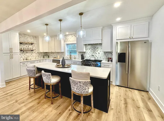 a kitchen with a dining table chairs refrigerator and cabinets