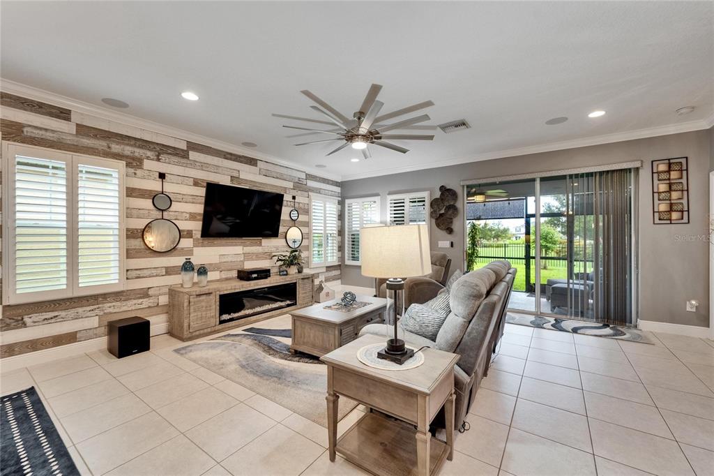6127 Colmar Place Apollo Beach, FL 33572 - Photo 32 of 72 a living room with furniture a flat screen tv and a floor to ceiling window
