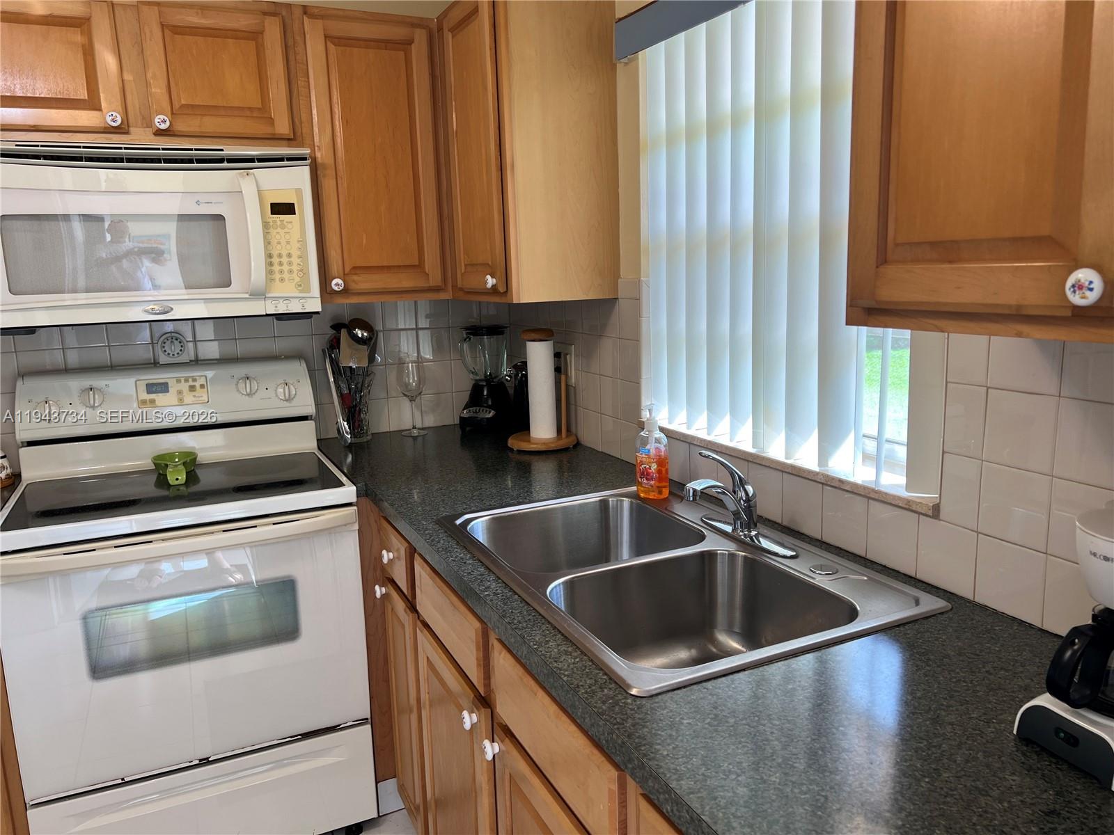 5300 Washington Street, Unit G123 Hollywood, FL 33021 - Photo 11 of 12 a kitchen with stainless steel appliances granite countertop a sink and a stove