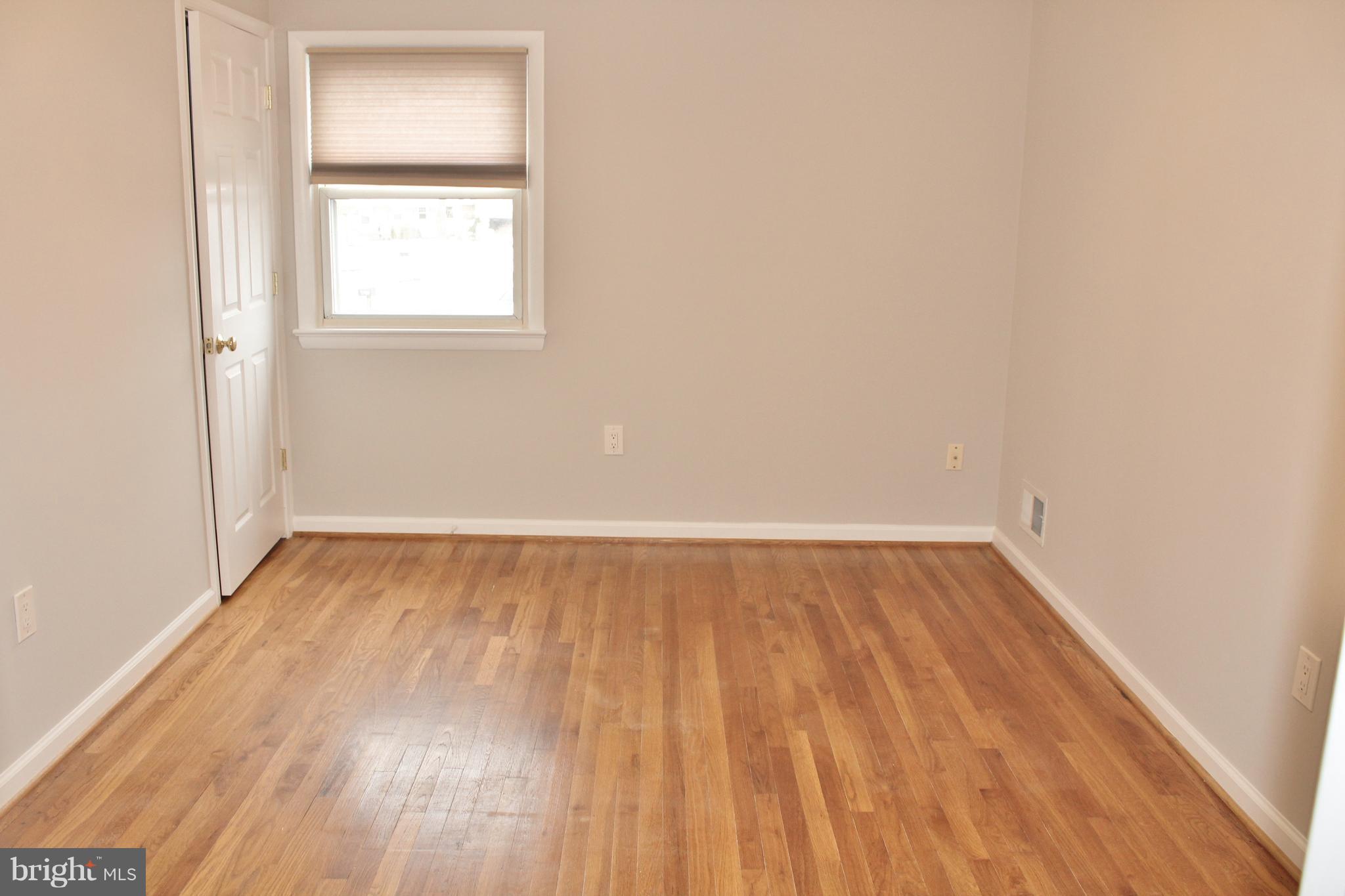 8004 Frye Road Alexandria, VA 22309 - Photo 8 of 21 a view of an empty room with wooden floor and a window