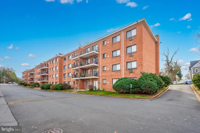 a front view of building with yard street and trees
