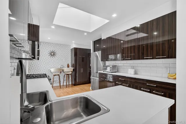 a kitchen with stainless steel appliances granite countertop a sink a stove and a refrigerator