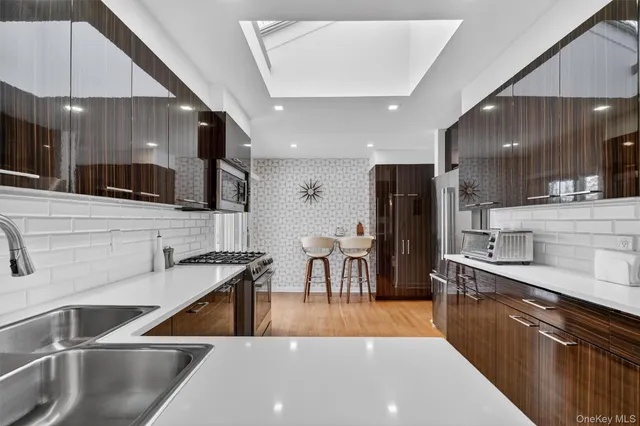 a kitchen with stainless steel appliances a sink a stove a refrigerator cabinets and a counter top space