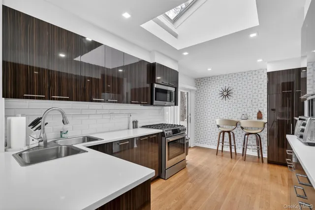 a kitchen with stainless steel appliances a stove cabinets and wooden floor