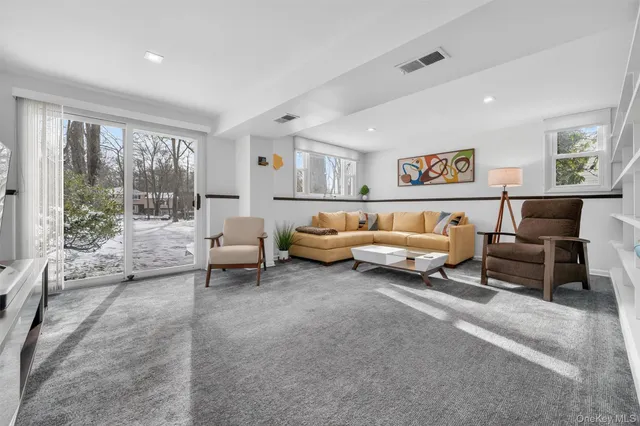 a living room with furniture and a book shelf