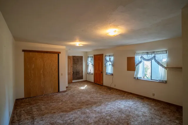 a view of a hallway with wooden floor and front door
