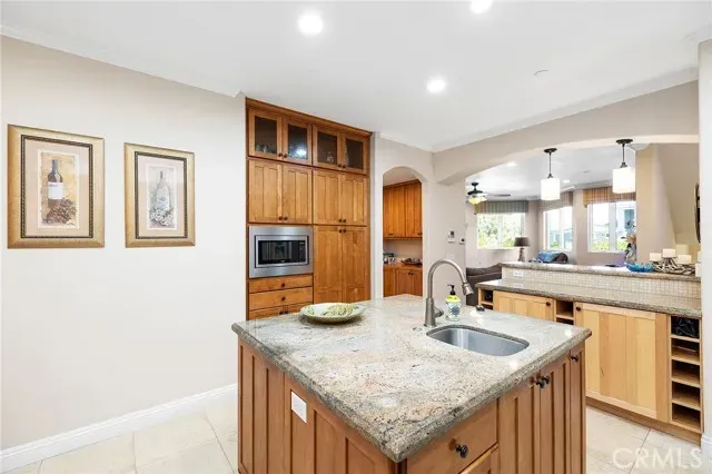 a kitchen with granite countertop a sink and dishwasher a refrigerator with wooden cabinets