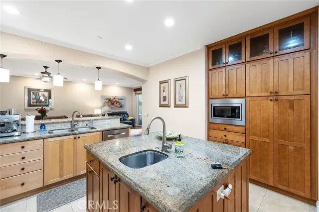 a kitchen with granite countertop a sink a counter space appliances and cabinets
