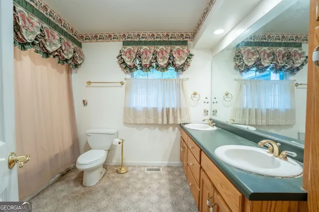 a view of a livingroom with a chandelier fan and windows