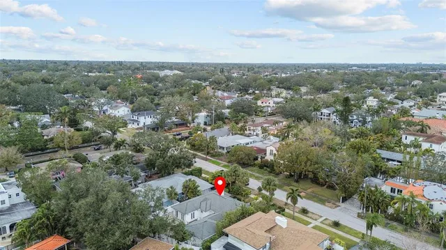 an aerial view of residential houses with outdoor space and trees