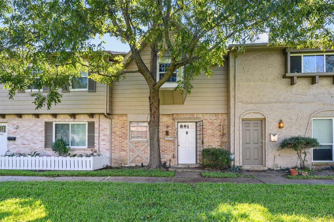 a front view of a house with a garden and yard