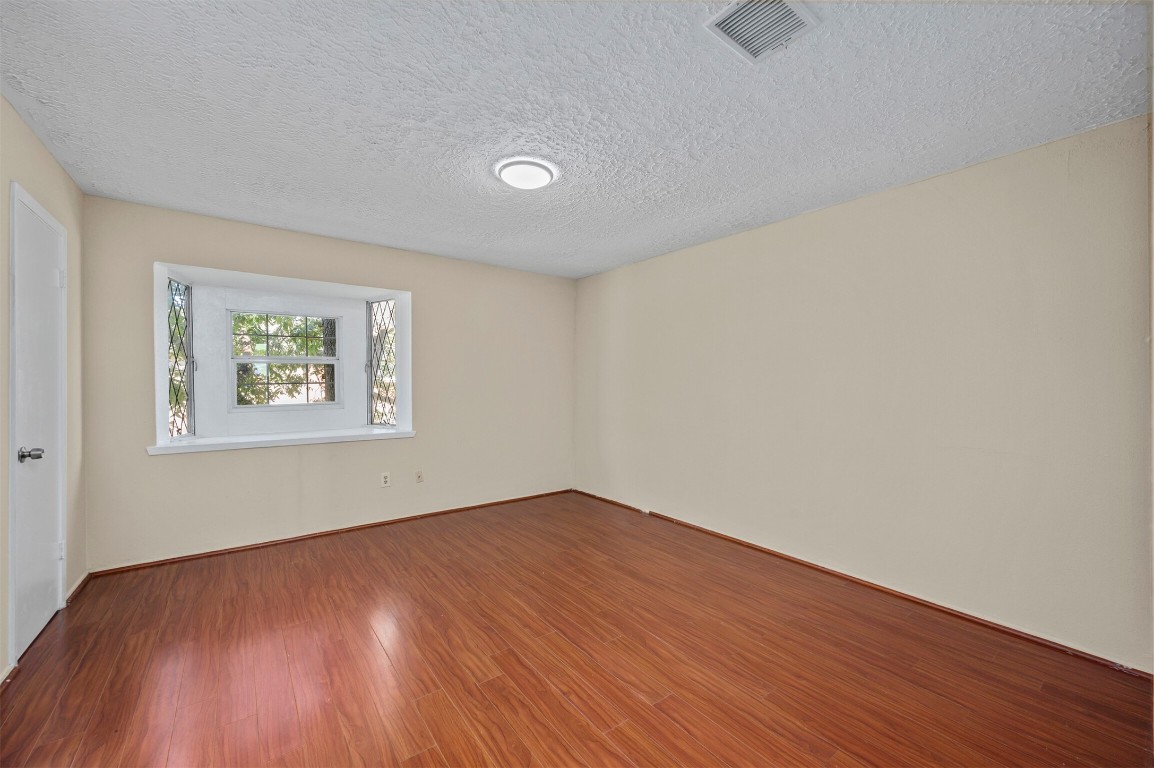 7236 Crownwest Street, Unit 7236 Houston, TX 77072 - Photo 11 of 21 an empty room with wooden floor and windows