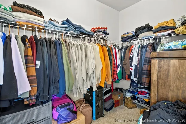 a view of walk in closet with clothes
