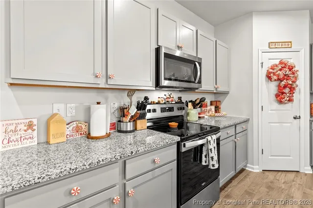 a kitchen with granite countertop stainless steel appliances a sink a stove and cabinets