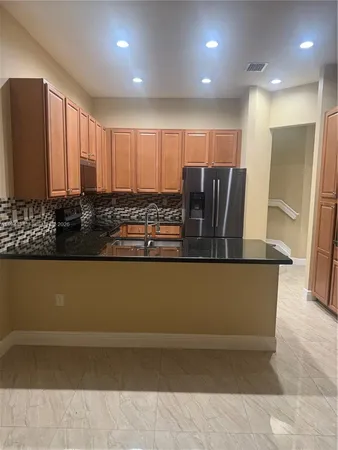a view of kitchen with stainless steel appliances granite countertop cabinets and a counter top space
