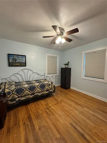 a bedroom with a bed and wooden floor