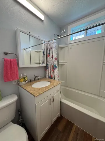 a bathroom with a granite countertop sink toilet and shower