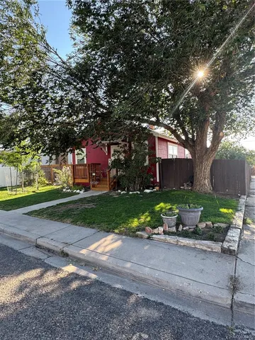 a front view of a house with a yard and tree s