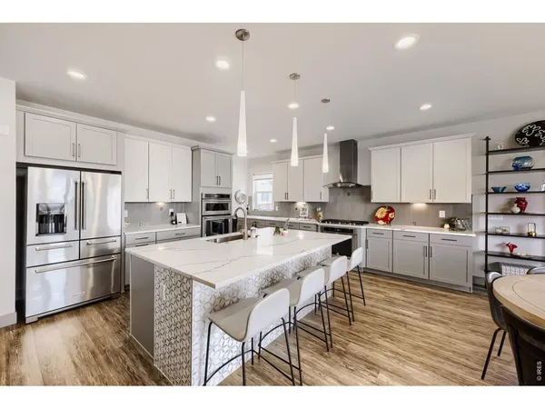 a kitchen with a table a refrigerator a cabinets and stools