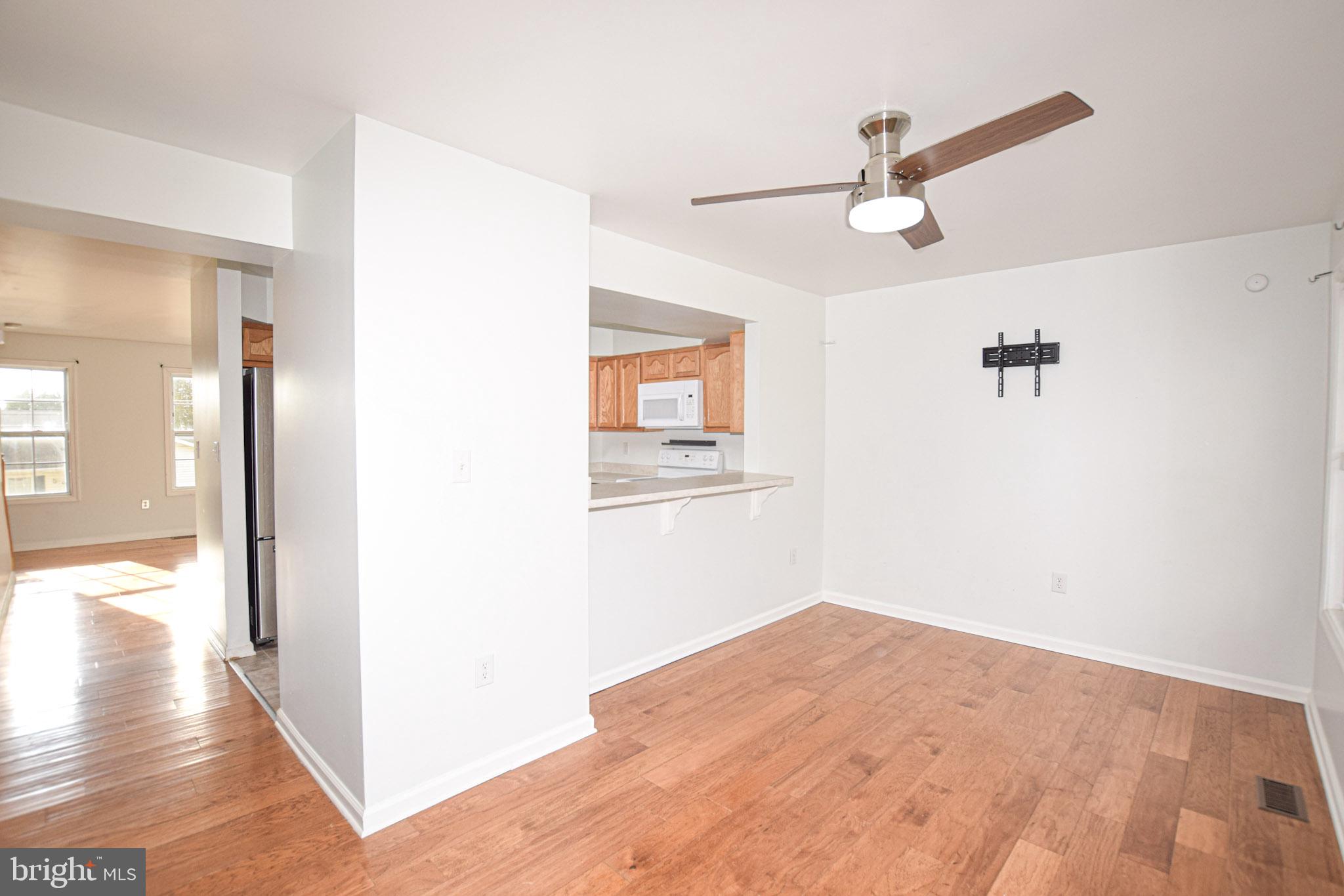 226 Topaz Lane Inwood, WV 25428 - Photo 12 of 32 a view of a hallway with wooden floor and a ceiling fan