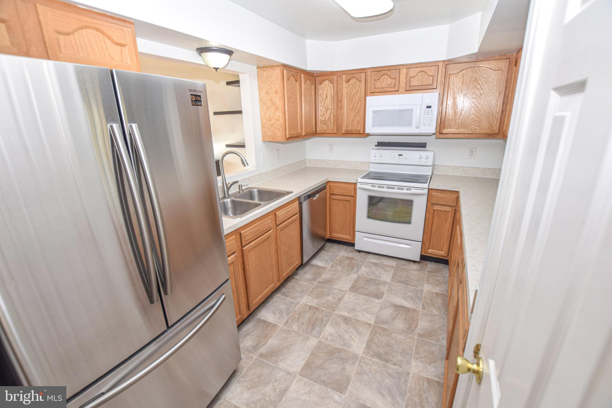 226 Topaz Lane Inwood, WV 25428 - Photo 8 of 32 a kitchen with granite countertop a refrigerator and a sink