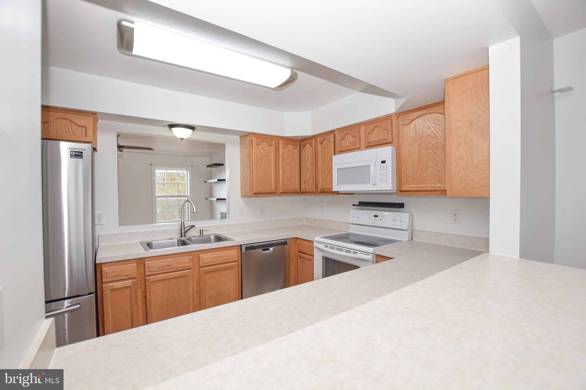 226 Topaz Lane Inwood, WV 25428 - Photo 9 of 32 a kitchen with stainless steel appliances granite countertop a sink stove and refrigerator