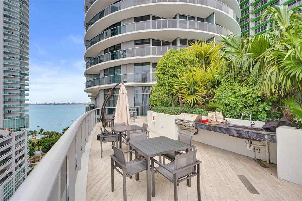 488 Northeast 18th Street, Unit 801 Miami, FL 33132 - Photo 26 of 46 a roof deck with table and chairs and potted plants