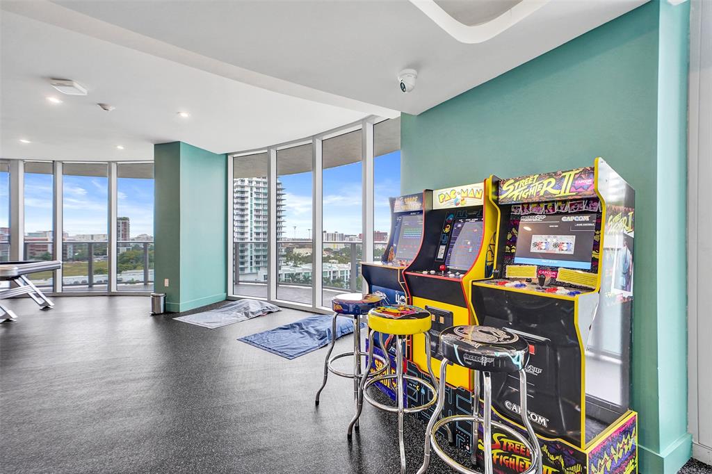 488 Northeast 18th Street, Unit 801 Miami, FL 33132 - Photo 38 of 46 a work room with furniture and a flat screen tv