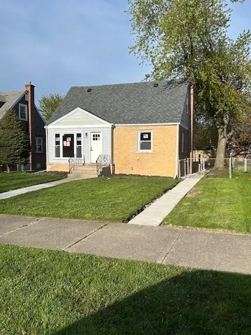 a view of a house with a yard and large trees