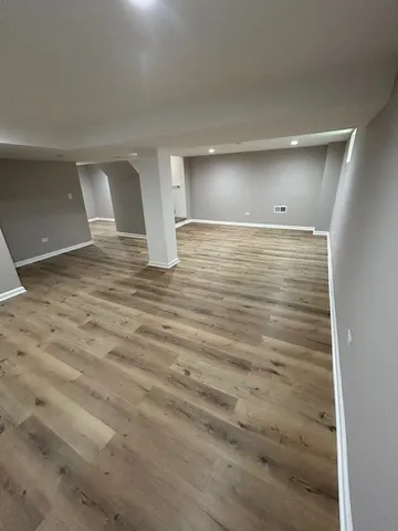 a view of empty room with wooden floor