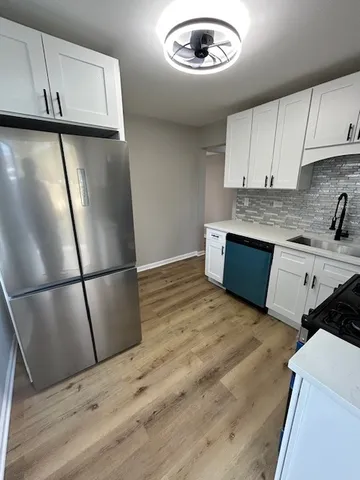 a view of kitchen with stainless steel appliances granite countertop cabinets and wooden floor