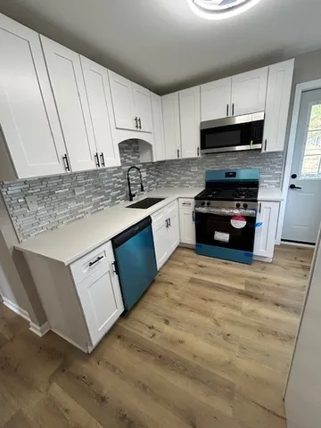 a kitchen with stainless steel appliances granite countertop a stove a sink and a microwave