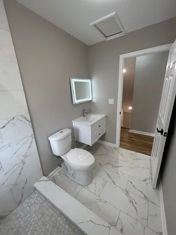 a white toilet sitting next to a bathroom sink