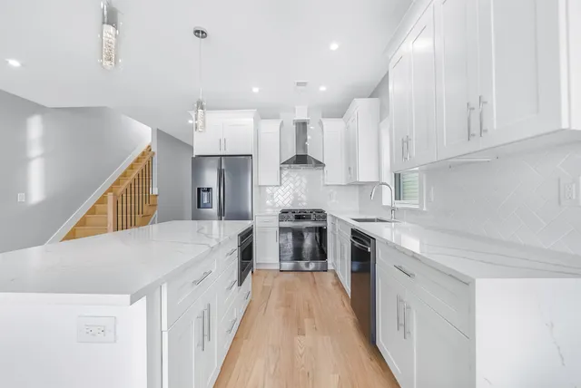 a large kitchen with stainless steel appliances granite countertop a lot of counter space and wooden floors