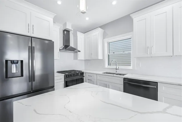 a kitchen with stainless steel appliances granite countertop a refrigerator sink and stove