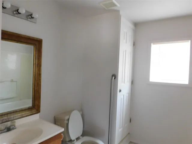 a bathroom with a toilet a sink and a mirror
